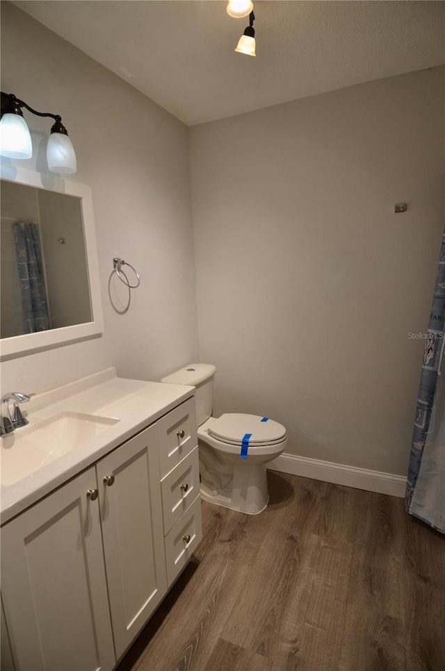 bathroom with vanity, toilet, and hardwood / wood-style floors