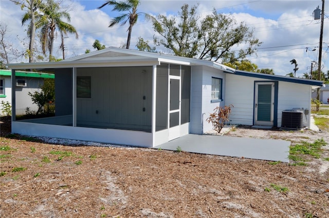 rear view of house featuring a sunroom and central AC unit