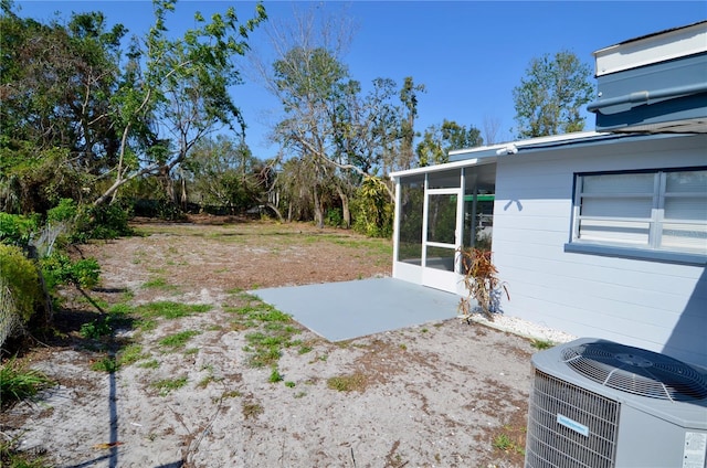 view of yard featuring a patio area, a sunroom, and central air condition unit