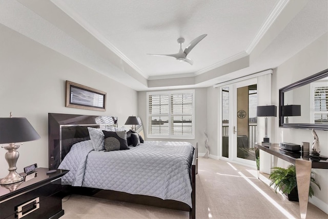 carpeted bedroom featuring crown molding, a tray ceiling, access to exterior, and ceiling fan