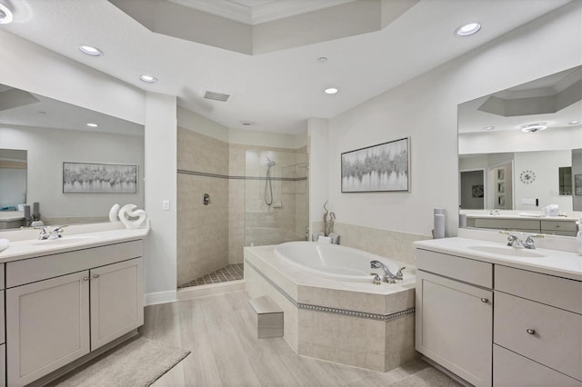 bathroom with separate shower and tub, vanity, and hardwood / wood-style flooring