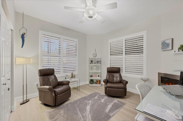 living area featuring ceiling fan and light hardwood / wood-style floors