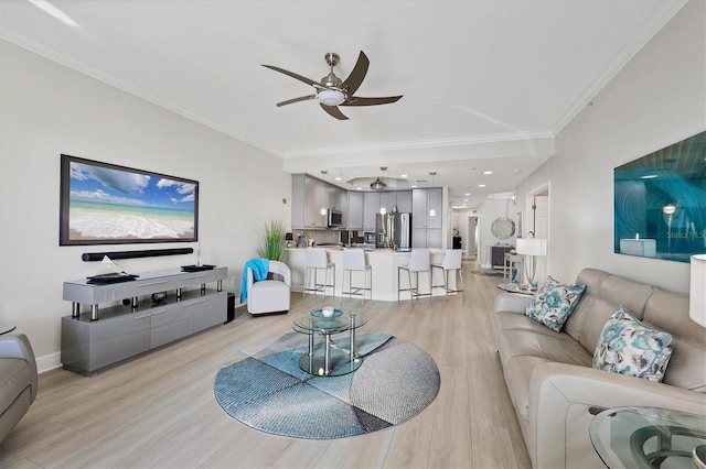 living room with ornamental molding, light hardwood / wood-style flooring, and ceiling fan