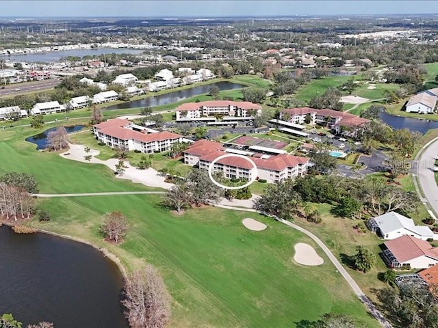 birds eye view of property with golf course view, a water view, and a residential view