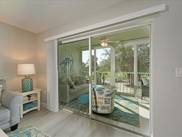 entryway featuring ceiling fan, plenty of natural light, a textured ceiling, and wood finished floors