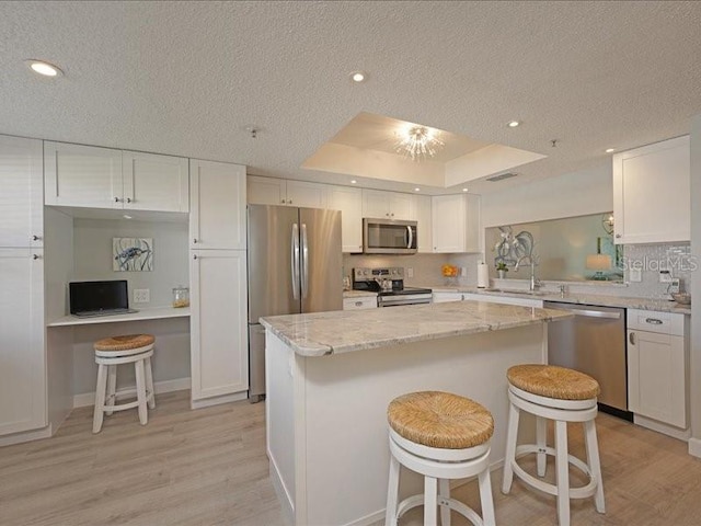 kitchen featuring appliances with stainless steel finishes, a breakfast bar, and white cabinets