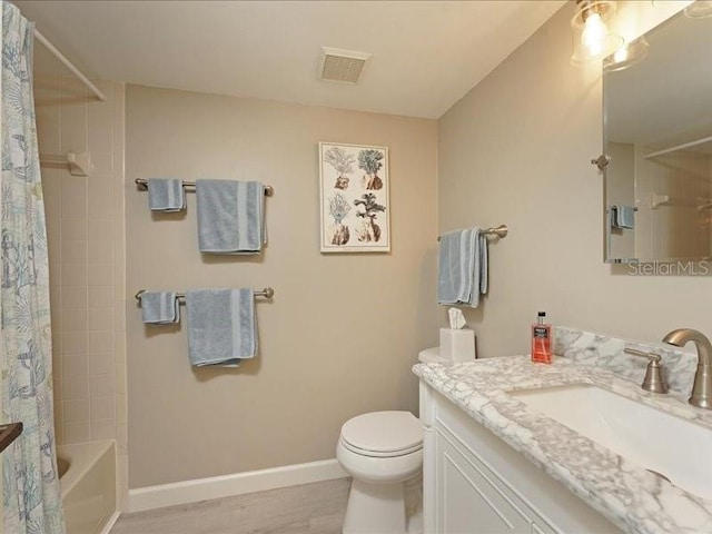 bathroom with toilet, shower / tub combo, vanity, visible vents, and baseboards