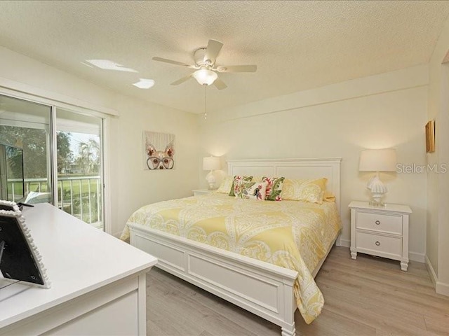 bedroom featuring a textured ceiling, wood finished floors, a ceiling fan, baseboards, and access to outside