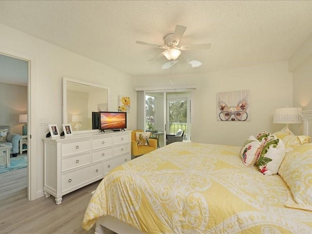 bedroom featuring a textured ceiling, light wood-style floors, and access to exterior