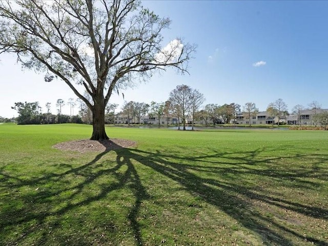 view of home's community with a water view and a lawn