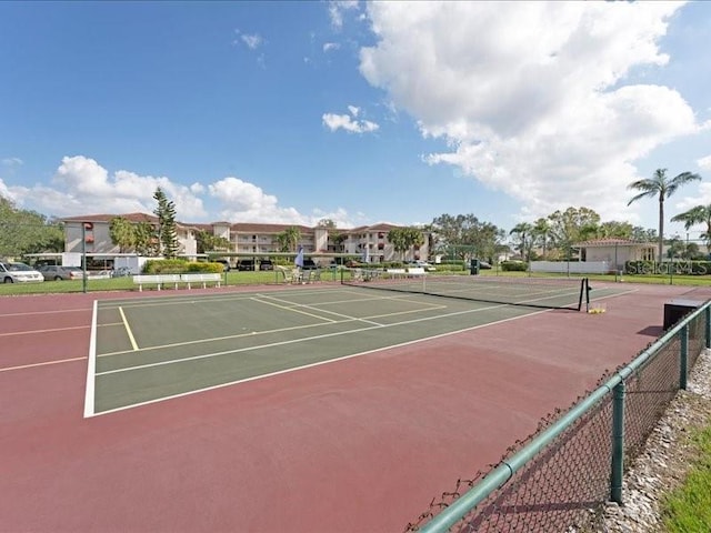 view of sport court with a residential view and fence