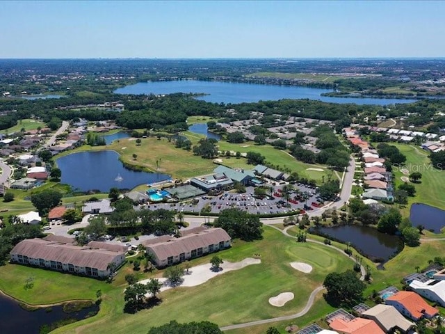 drone / aerial view with view of golf course and a water view