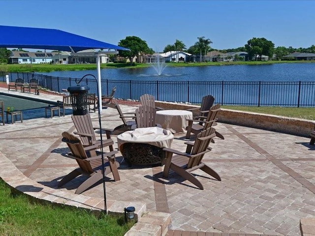 view of patio / terrace with a water view and fence