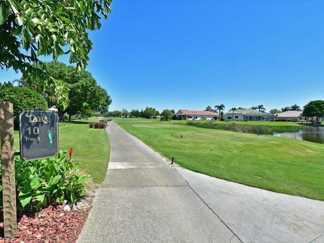 view of home's community with a water view and a lawn