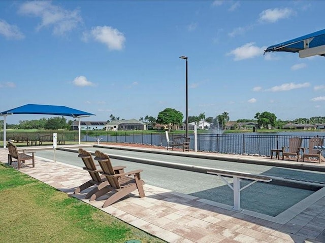 view of property's community featuring a water view and fence