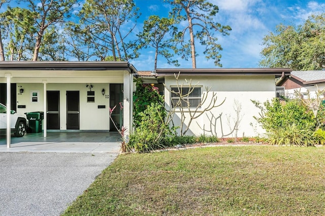 view of front of home with a front yard and a carport