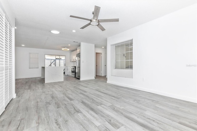 unfurnished living room with recessed lighting, ceiling fan, light wood-type flooring, and baseboards