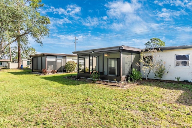 back of house with a yard and a sunroom