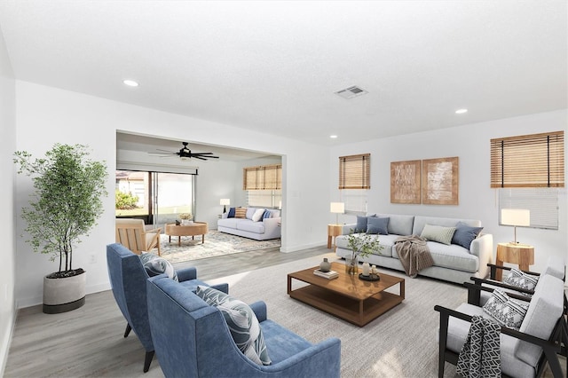 living room with visible vents, baseboards, recessed lighting, wood finished floors, and a ceiling fan