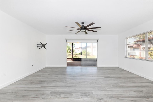 empty room featuring a ceiling fan, baseboards, and wood finished floors