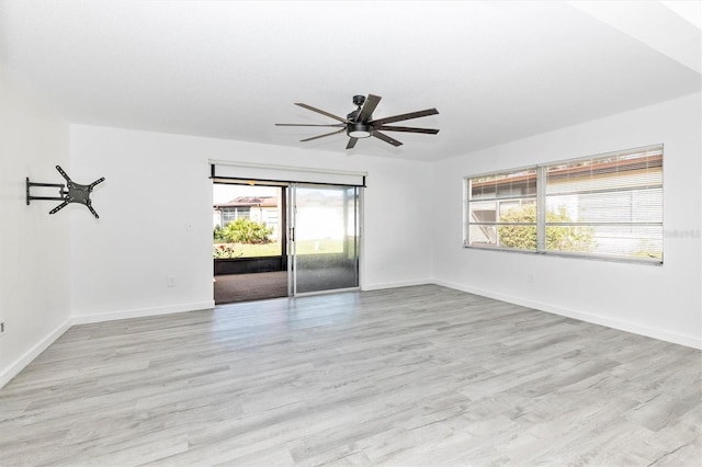 empty room with baseboards, a ceiling fan, and wood finished floors