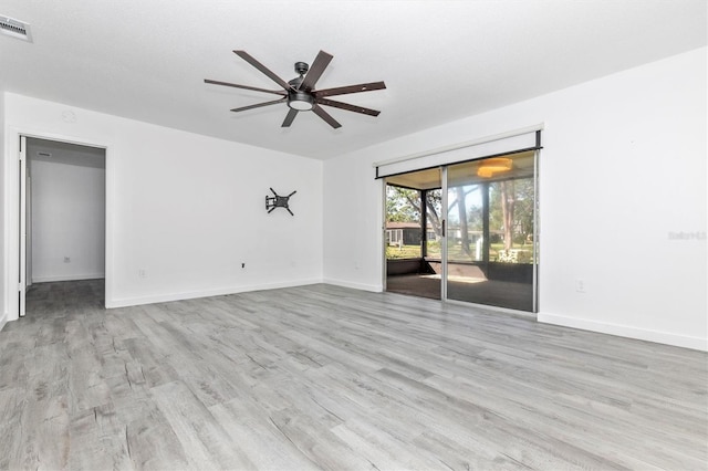 spare room with baseboards, ceiling fan, and wood finished floors