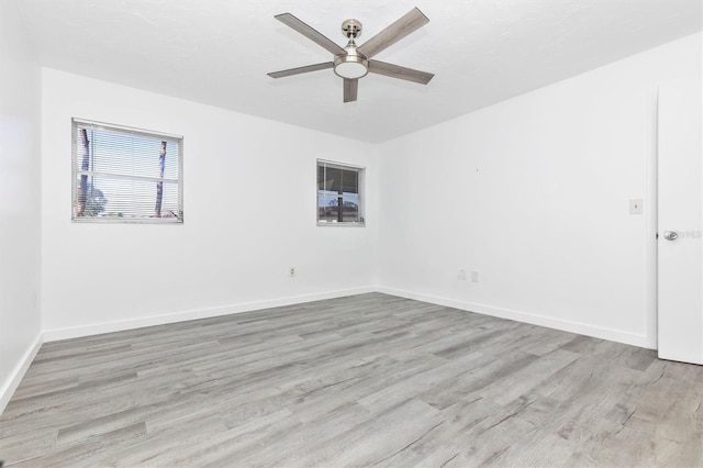 empty room featuring baseboards, ceiling fan, and wood finished floors