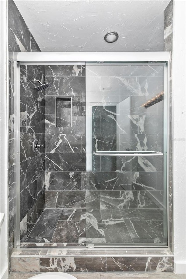 bathroom with a marble finish shower