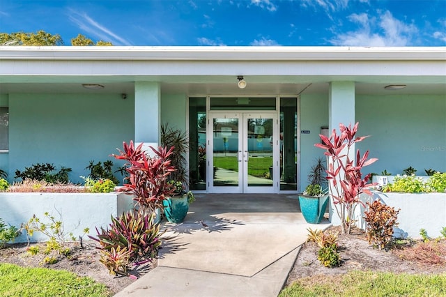 property entrance featuring stucco siding and french doors