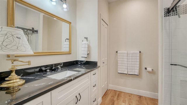 4060 Penshurst Park, Sarasota, FL 34235 - full bath featuring baseboards, wood finished floors, vanity, and tiled shower