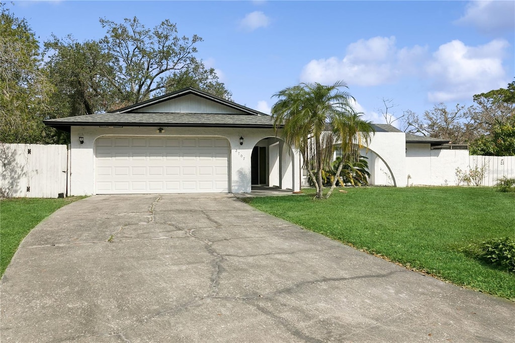 ranch-style home featuring a garage and a front yard