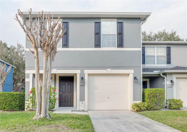 view of front of house with an attached garage, driveway, and stucco siding