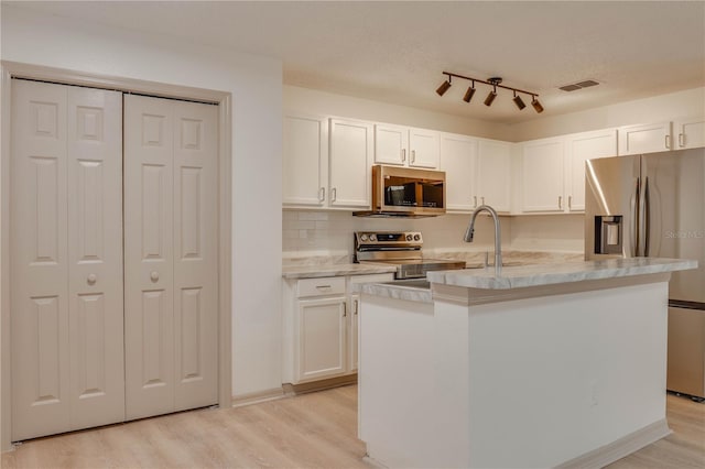 kitchen with stainless steel appliances, a kitchen island with sink, white cabinets, and visible vents