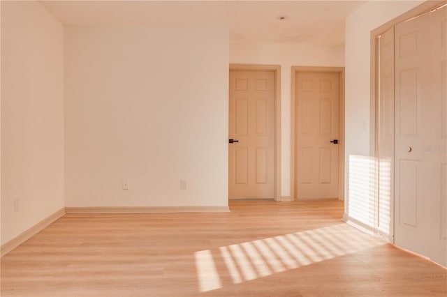 interior space featuring light wood-type flooring and baseboards