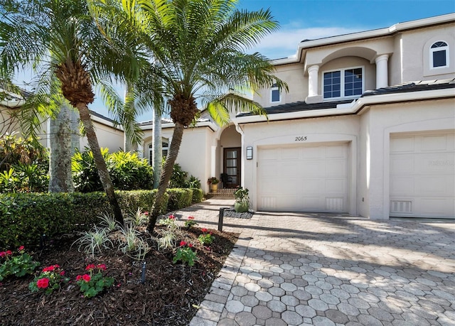 mediterranean / spanish house featuring a garage and stucco siding