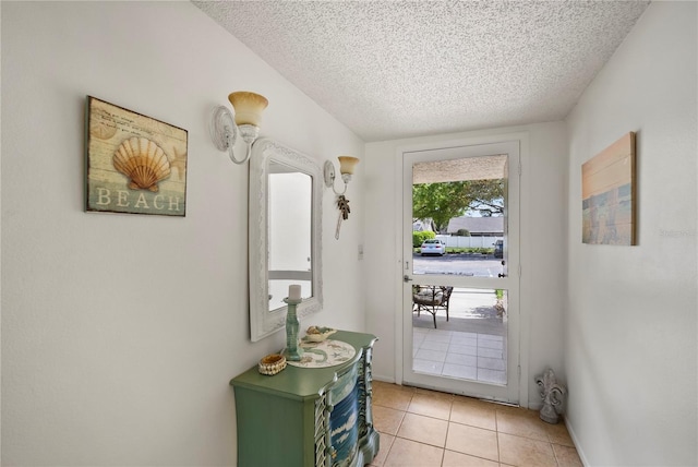 entryway with a textured ceiling and light tile patterned flooring