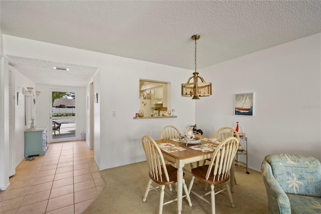 tiled dining room featuring a textured ceiling