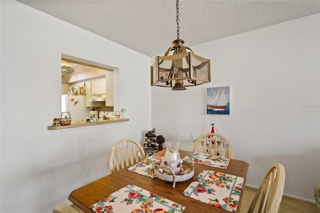 dining area featuring an inviting chandelier and a textured ceiling