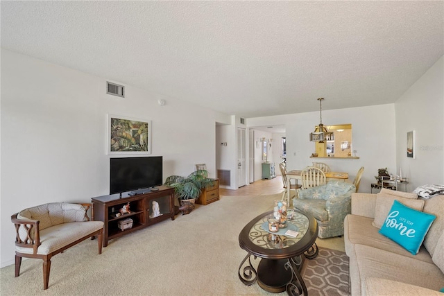 living room with light colored carpet and a textured ceiling