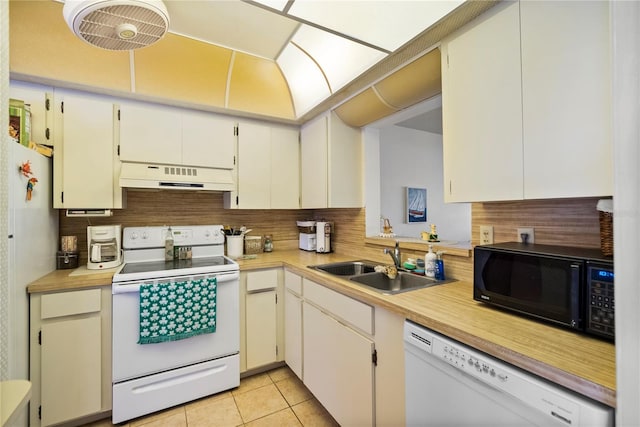 kitchen featuring lofted ceiling, sink, light tile patterned floors, white appliances, and backsplash