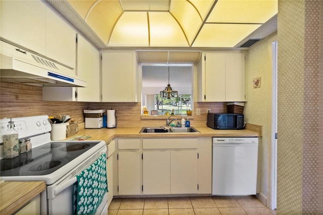 kitchen featuring light tile patterned floors, white appliances, sink, tasteful backsplash, and decorative light fixtures