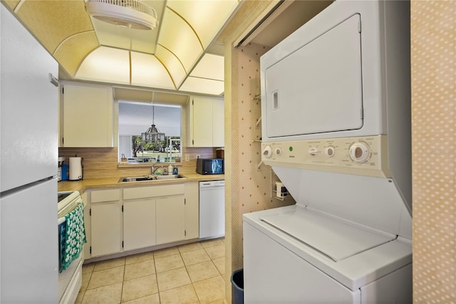 laundry room featuring sink, stacked washer and clothes dryer, and light tile patterned flooring