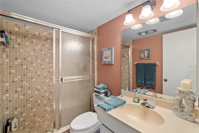 bathroom with vanity, a shower with shower door, and toilet