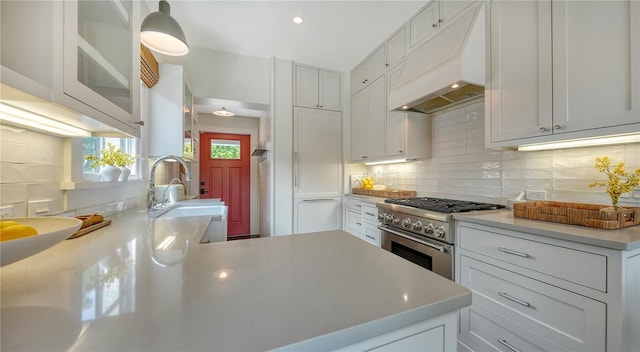 kitchen featuring sink, custom exhaust hood, white cabinets, and high end stainless steel range oven