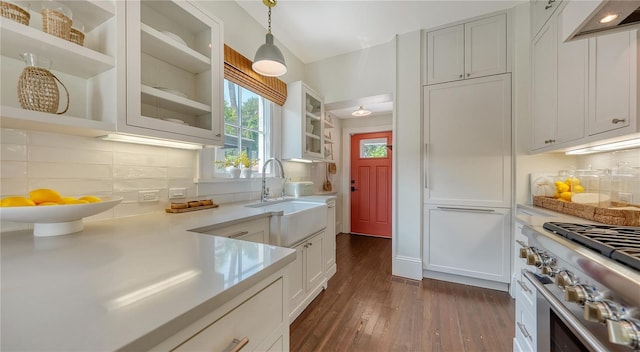 kitchen featuring stainless steel stove, decorative light fixtures, sink, white cabinets, and dark wood-type flooring