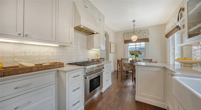 kitchen with white cabinetry, hanging light fixtures, and high end stainless steel range