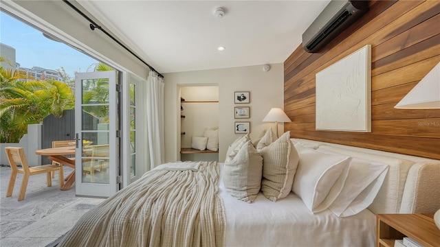 bedroom featuring an AC wall unit, access to exterior, and wood walls