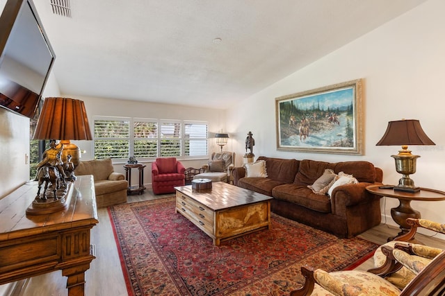 living room featuring vaulted ceiling and hardwood / wood-style floors