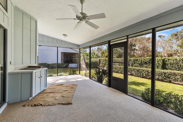 unfurnished sunroom featuring ceiling fan, lofted ceiling, and a wealth of natural light