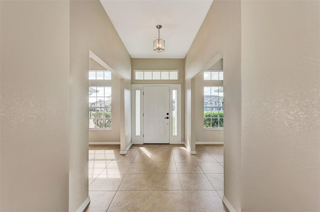 tiled foyer featuring a towering ceiling and a wealth of natural light